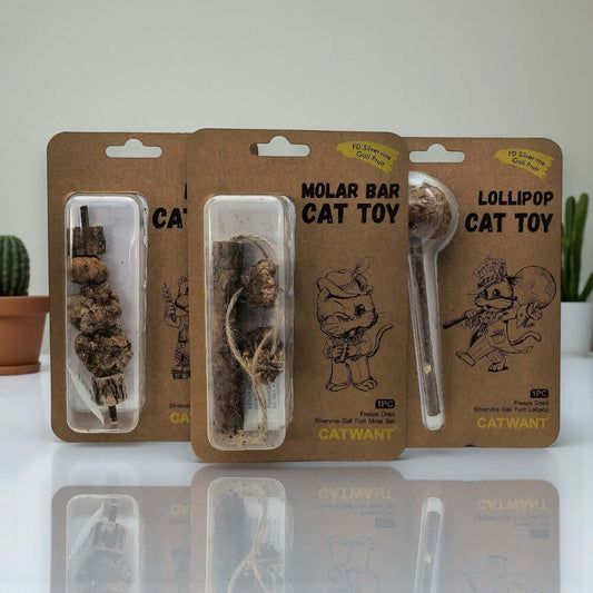 Three cat toys in the packaging on a marble countertop, molar bar, lollipop and kebab made of silvervine.
