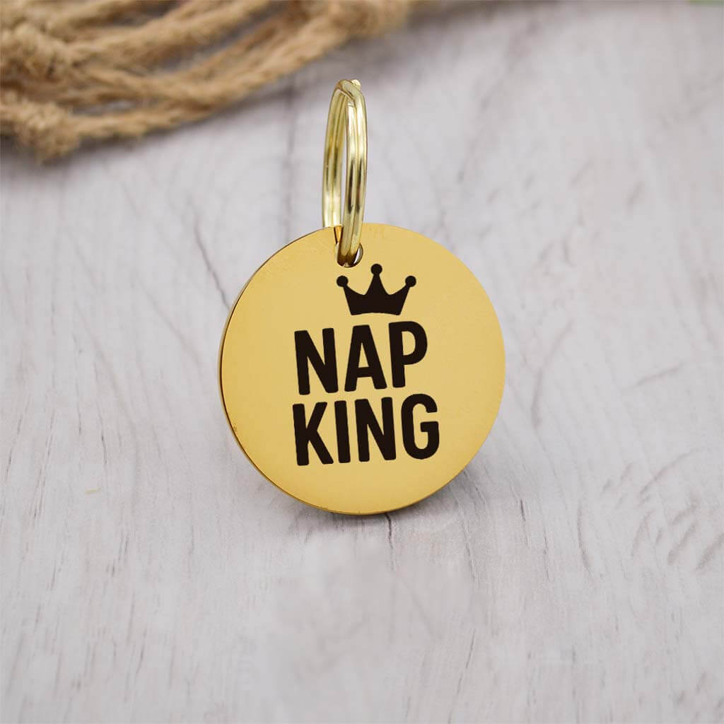 Funny gold pet ID tag with 'Nap King' engraved — personalized dog or cat tag for pet safety and identification.
